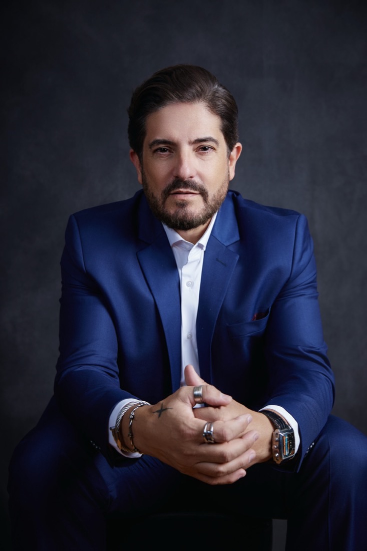 Anderson Martin, de terno azul, sentado com as mãos cruzadas